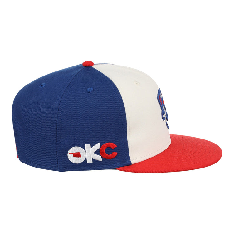 The Ebbets Field Oklahoma City 89Ers MiLB Snapback Ballcap features a blue crown, white front panel, red brim and button, and OKC embroidered on the side in white and red.