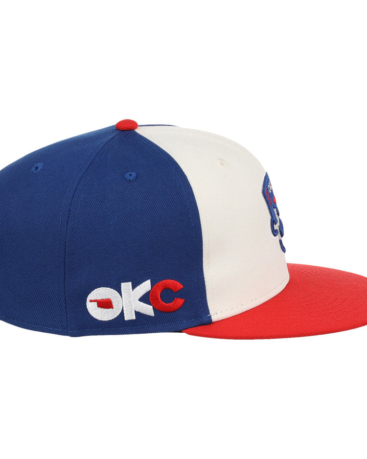 The Ebbets Field Oklahoma City 89Ers MiLB Snapback Ballcap features a blue crown, white front panel, red brim and button, and OKC embroidered on the side in white and red.