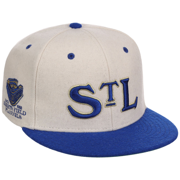 The Ebbets Field St. Louis Stars NLB Ballpark Fitted Ballcap features a white crown, blue brim and button, “STL” embroidered on the front, and a “Shea’s Field 1988 Panels” patch on the side.