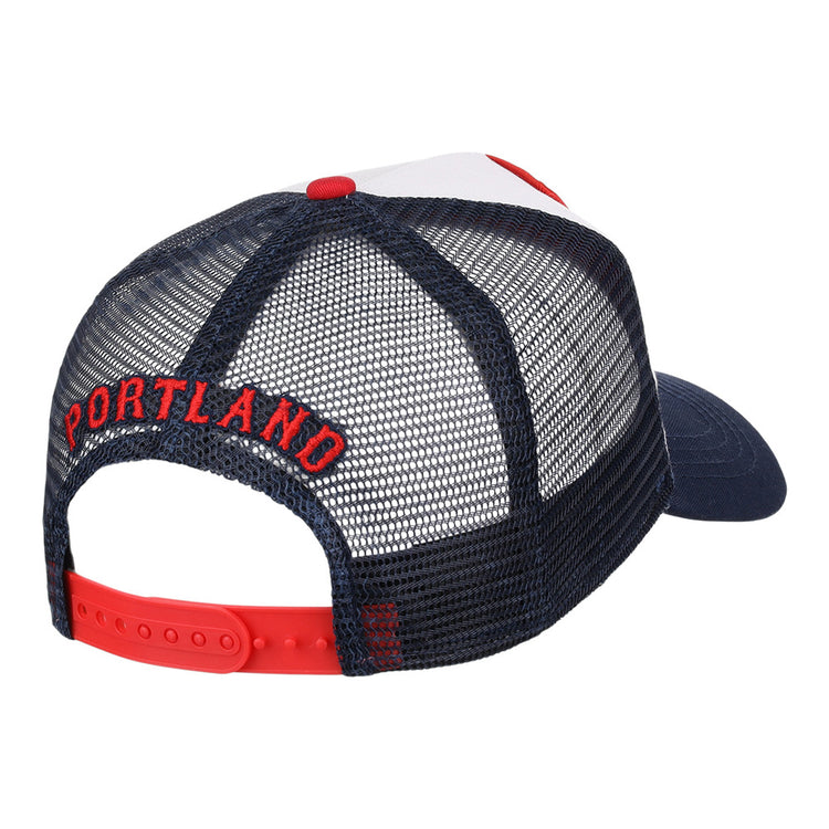 The Ebbets Field Portland Sea Dogs MiLB Trucker Ballcap is a navy blue mesh hat with a red adjustable snapback and PORTLAND embroidered in red above the back opening.