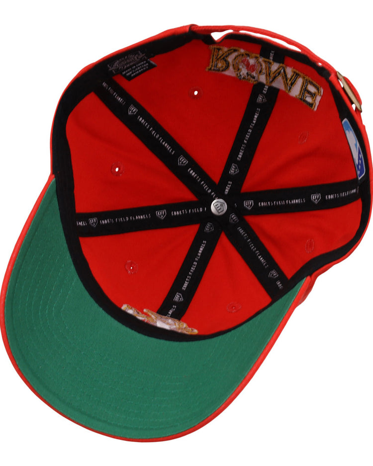 The Rome Emperors MiLB Dad Ballcap by Ebbets Field is red and flipped upside down, showing a green underbrim, black inner lining with white text, and embroidered crown patches including the word LOVE.