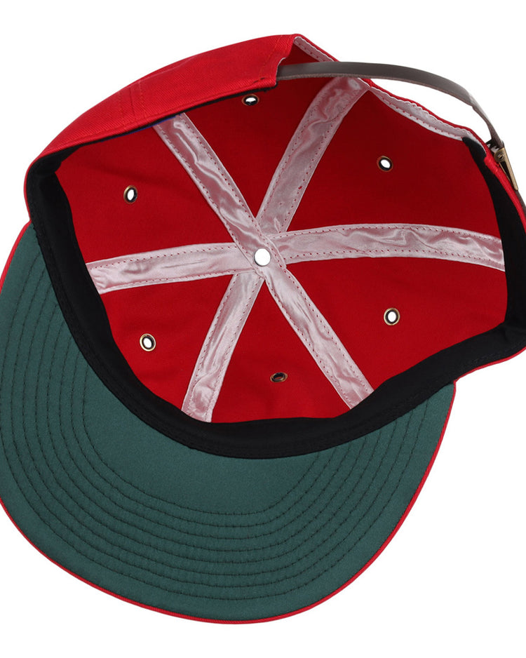The image shows the inside of an Ebbets Field Seattle Rainiers MiLB Cotton Ballcap with a red crown, green underbill, black trim, white seams, and an adjustable strap at the back.