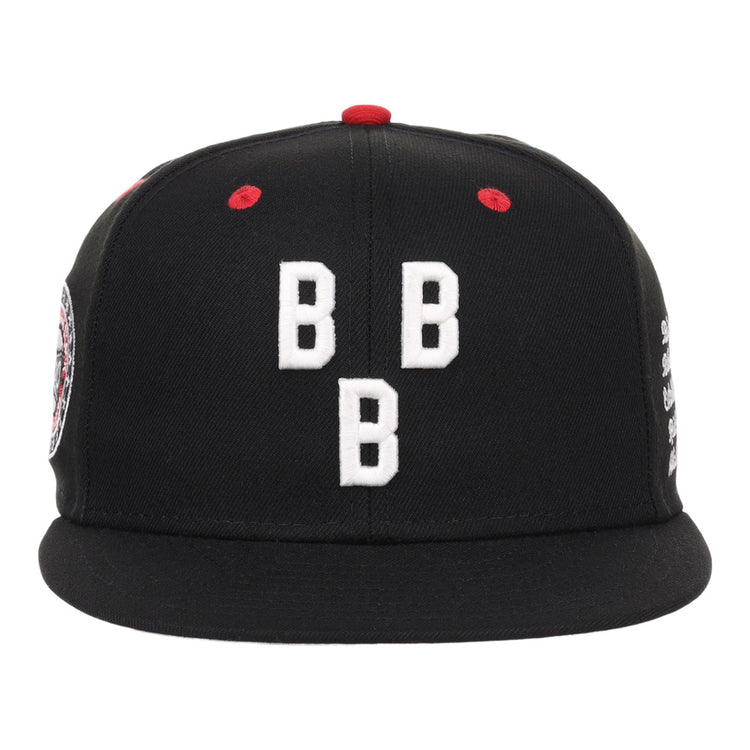The Birmingham Black Barons NLB Varsity Fitted Ballcap by Ebbets Field is a black hat featuring three white embroidered Bs on the front and red stitching accents.