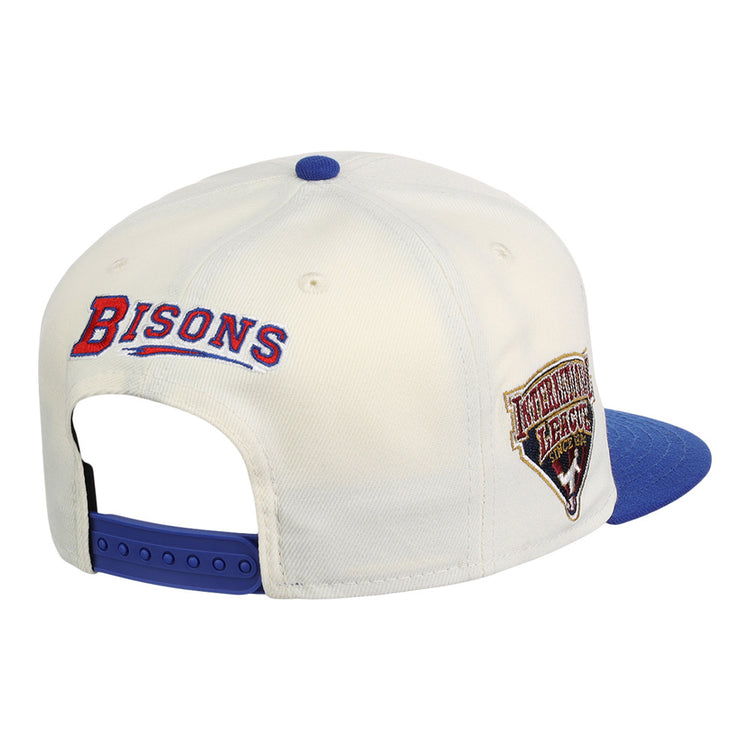 The Buffalo Bisons MiLB Snapback Ballcap by Ebbets Field is a white cap with a blue brim, BISONS embroidered in red and blue on the back, and an International League patch on the side.