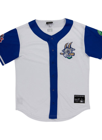 The Ebbets Field Hartford Yard Goats MiLB Button Down Jersey is white with blue sleeves and trim, a cartoon goat logo on the chest, sleeve patches, button-down front, and a black label near the hem.