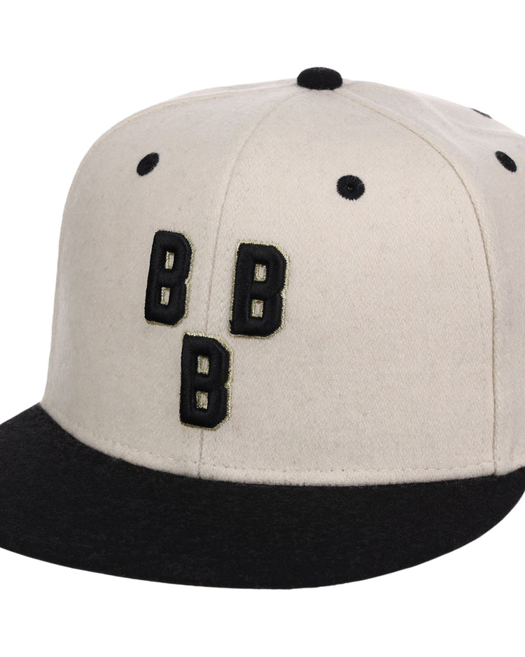 The Ebbets Field Birmingham Black Barons NLB Ballpark Fitted Ballcap features a beige crown, black brim and eyelets, plus three black Bs outlined in white on the front.