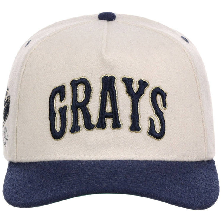 The Ebbets Field Homestead Grays NLB Ballpark A-Frame Ballcap is cream-colored with a navy brim and button, featuring 