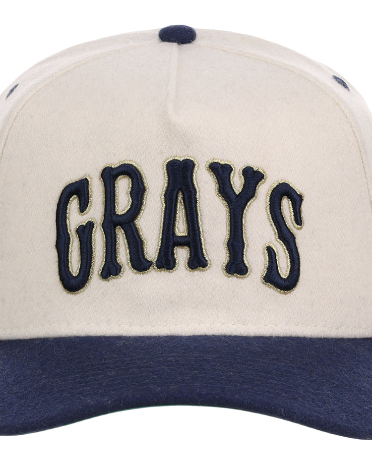 The Ebbets Field Homestead Grays NLB Ballpark A-Frame Ballcap is cream-colored with a navy brim and button, featuring 