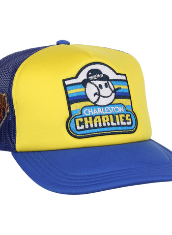 The Ebbets Field Charleston Charlies MiLB Logo Wordmark Vintage Foam Trucker Ballcap is a yellow and blue mesh-back hat, featuring a cartoon baseball player with “Charleston Charlies” on the front and a Charleston Athletics patch on the side.
