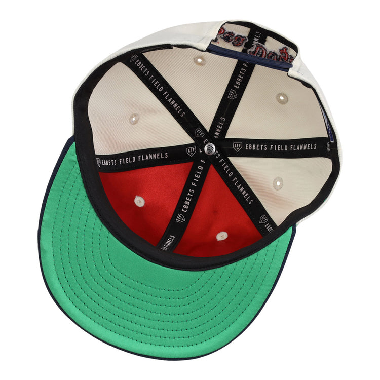 The inside of the Portland Sea Dogs MiLB Snapback Ballcap by Ebbets Field features a green brim, red lining, black and white stitching, Ebbets Field branding on black tape, and a decorative patch inside the crown.