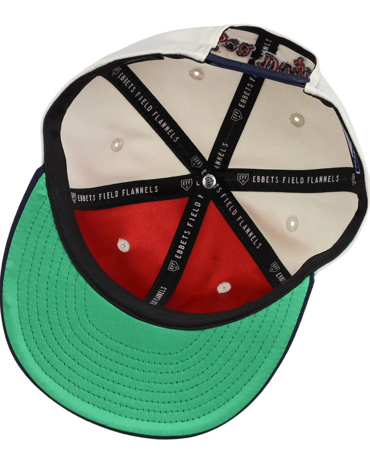 The inside of the Portland Sea Dogs MiLB Snapback Ballcap by Ebbets Field features a green brim, red lining, black and white stitching, Ebbets Field branding on black tape, and a decorative patch inside the crown.