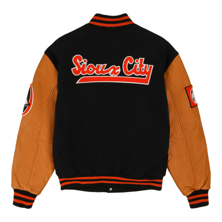 The Sioux City Ghosts NLB DNA Varsity Jacket by Ebbets Field features tan leather sleeves, a black wool body, black/red striped trim, sleeve patches, and bold red-and-white 