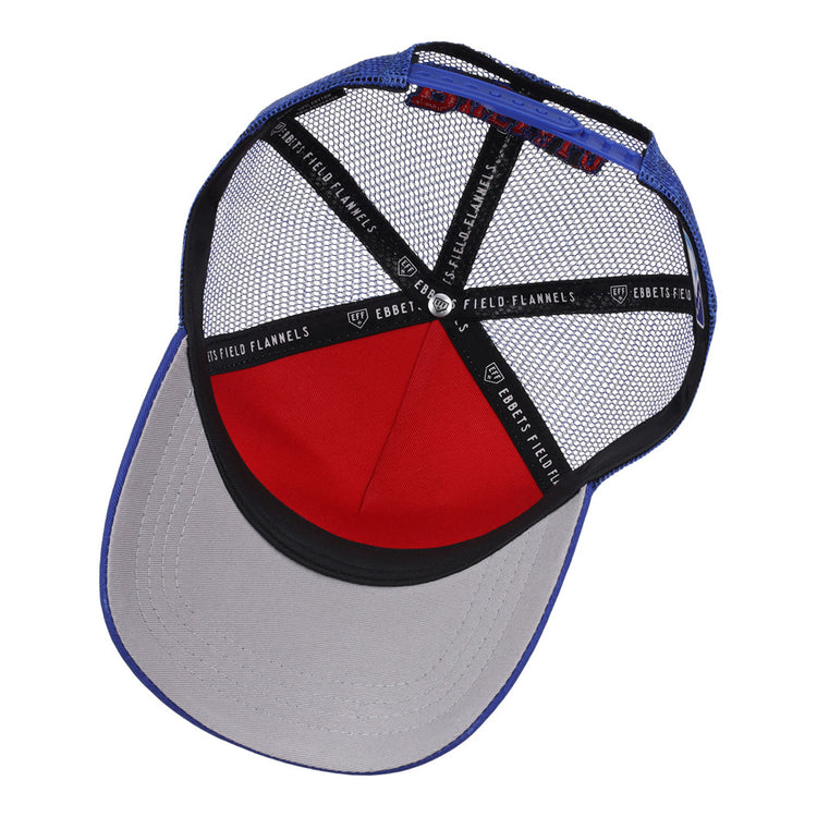 The Buffalo Bisons MiLB Trucker Ballcap by Ebbets Field features a blue crown, grey brim, red front panel, black mesh back, and interior seams lined with Ebbets Field branded tape.
