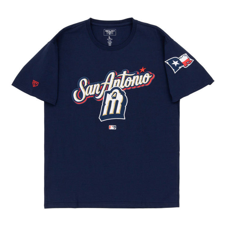The Ebbets Field San Antonio Missions MiLB Fashion Cotton Short Sleeve Tee features a navy design with San Antonio and an M logo on the front, a Texas flag patch on the right sleeve, and an MLB logo below the graphic.