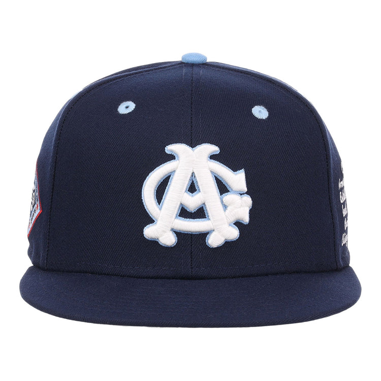 The Ebbets Field Chicago American Giants NLB Varsity Fitted Ballcap features a navy blue body, white interlocking A and C logo, light blue eyelets, flat brim, and additional side panel patches.