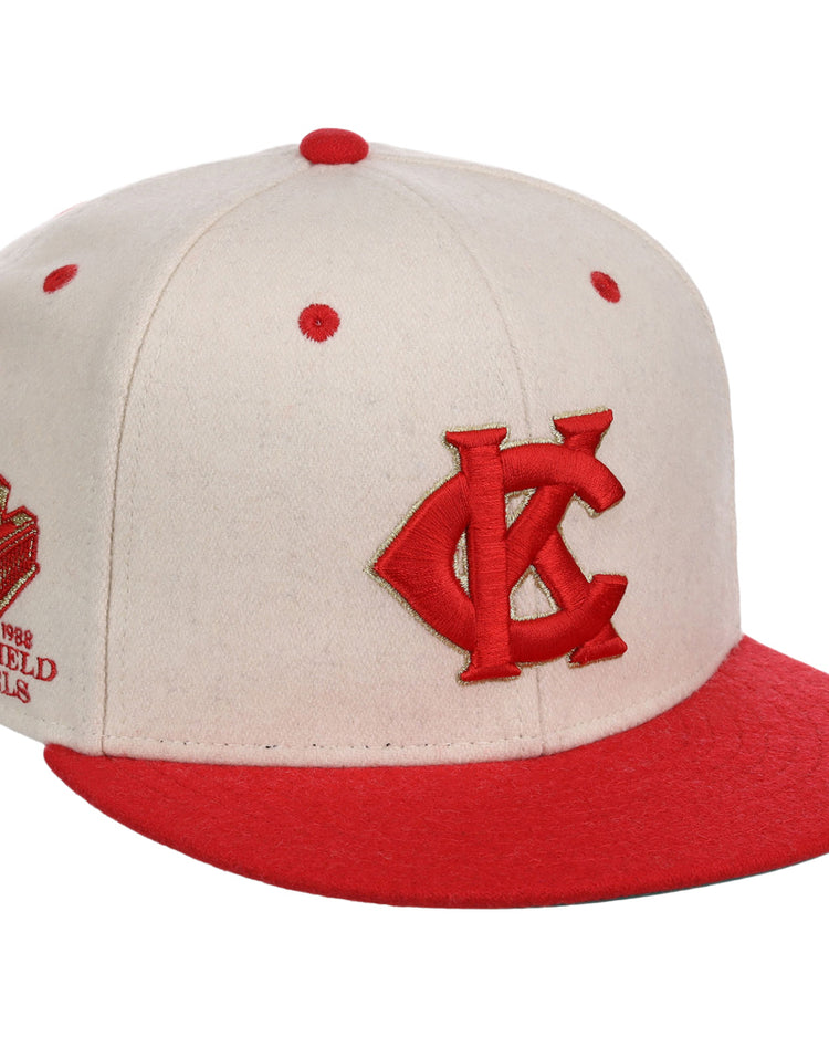 The Ebbets Field Kansas City Monarchs NLB Ballpark Fitted Ballcap is a cream cap with red accents, a red KC logo on the front, an embroidered side patch, and red brim and top button.