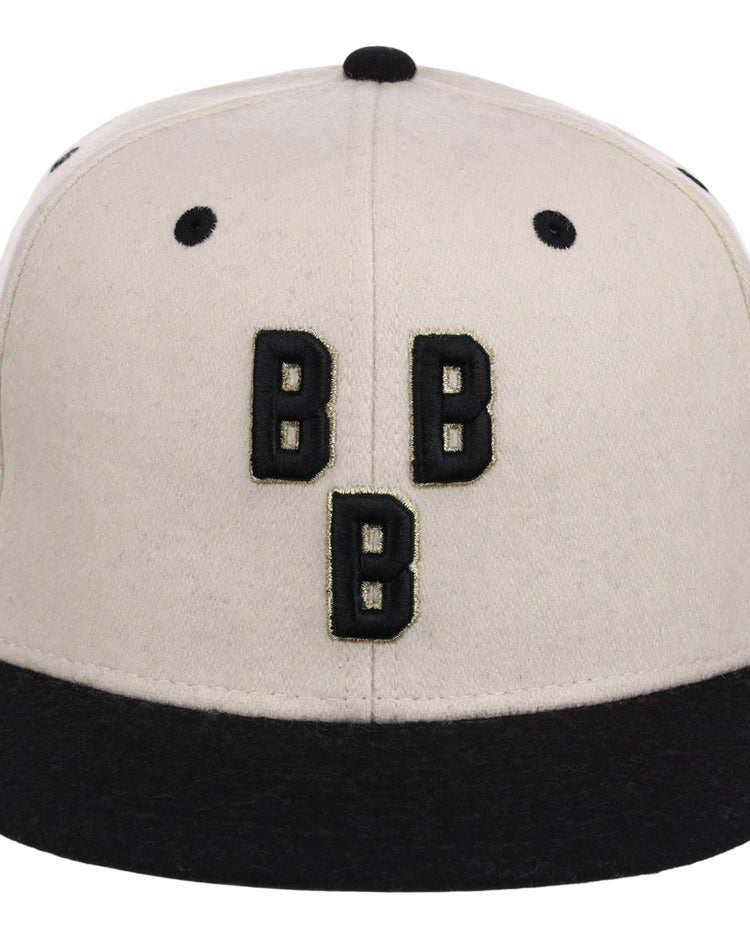 The Ebbets Field Birmingham Black Barons NLB Ballpark Fitted Ballcap is beige with a black brim and button, featuring three bold, black Bs arranged vertically on the front.