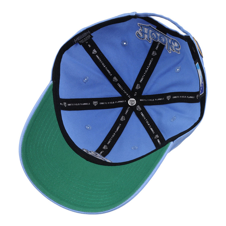A light blue Ebbets Field Corpus Christi Hooks MiLB Dad Ballcap viewed from underneath, featuring a green underbrim, black CREW x FIELD FLANNELS interior taping, silver eyelets, and a Hooks logo embroidered inside.