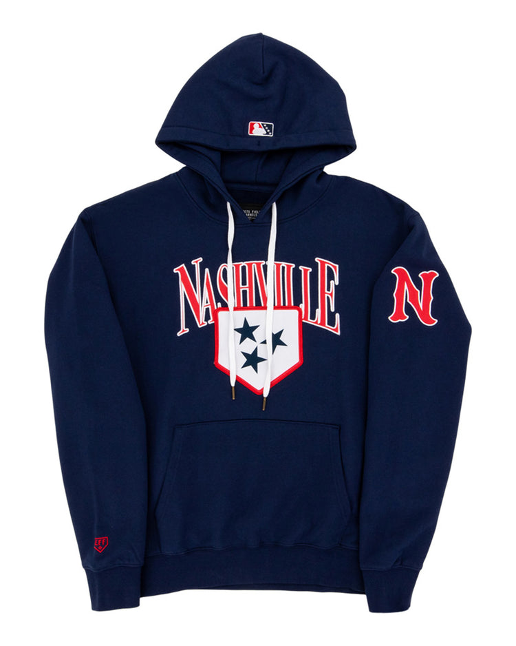 The Ebbets Field Nashville Sounds MiLB Cotton Hooded Sweatshirt is a navy blue hoodie with white drawstrings, Nashville in bold white and red letters, a three-star shield on the chest, red N on the sleeve, and an MLB logo on the hood.