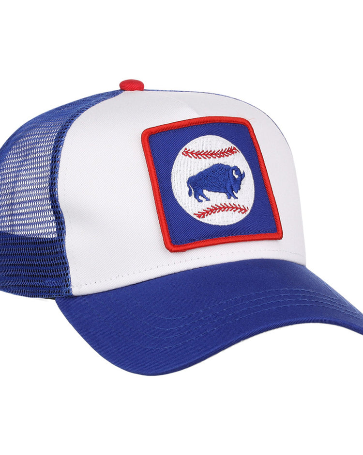 The Ebbets Field Buffalo Bisons MiLB Trucker Ballcap features a blue and white design with mesh back, plus a front patch showing a blue buffalo inside a red-bordered square, over two red baseball stitches on a white circle.