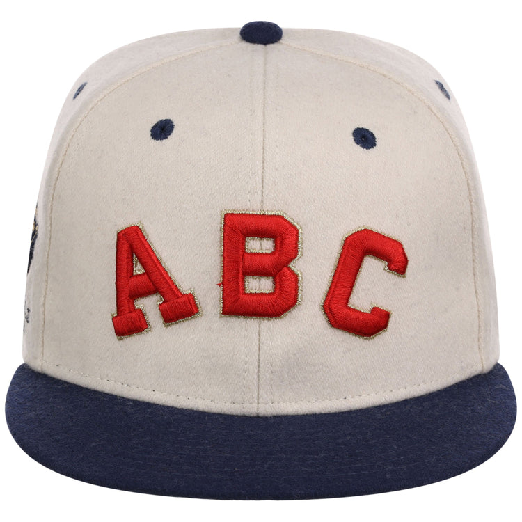 The Atlanta Black Crackers NLB Ballpark Fitted Ballcap by Ebbets Field is a beige cap with a dark blue brim, button, and eyelets, featuring large red 