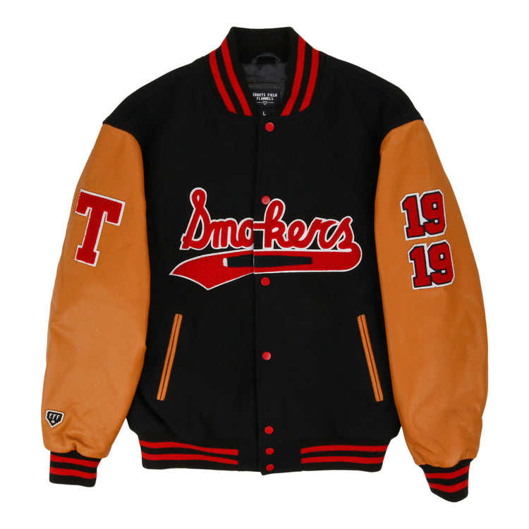 The Ebbets Field Tampa Smokers MiLB DNA Varsity Jacket features a black body, tan leather sleeves, red/white striped cuffs, 