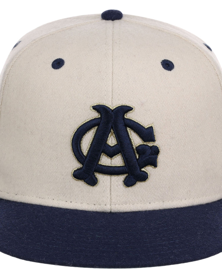 The Ebbets Field Chicago American Giants NLB Ballpark Fitted Ballcap features a cream crown, navy brim and button, and a dark blue interlocking CA logo outlined in gold on the front.