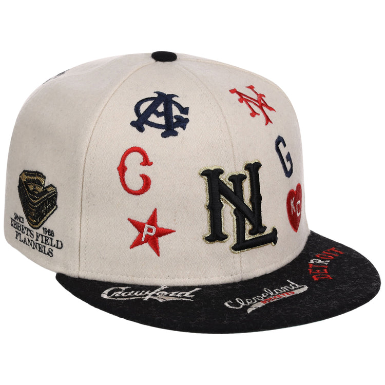 The Ebbets Field Negro League Baseball NLB Ballpark Fitted Ballcap is a white and black cap featuring colorful embroidered Negro League team logos, initials, and symbols on the front, top, and brim.