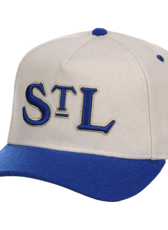 The Ebbets Field St. Louis Stars NLB Ballpark A-Frame Ballcap is beige with a royal blue brim and top button, featuring “STL” embroidered in blue and gold on the front.