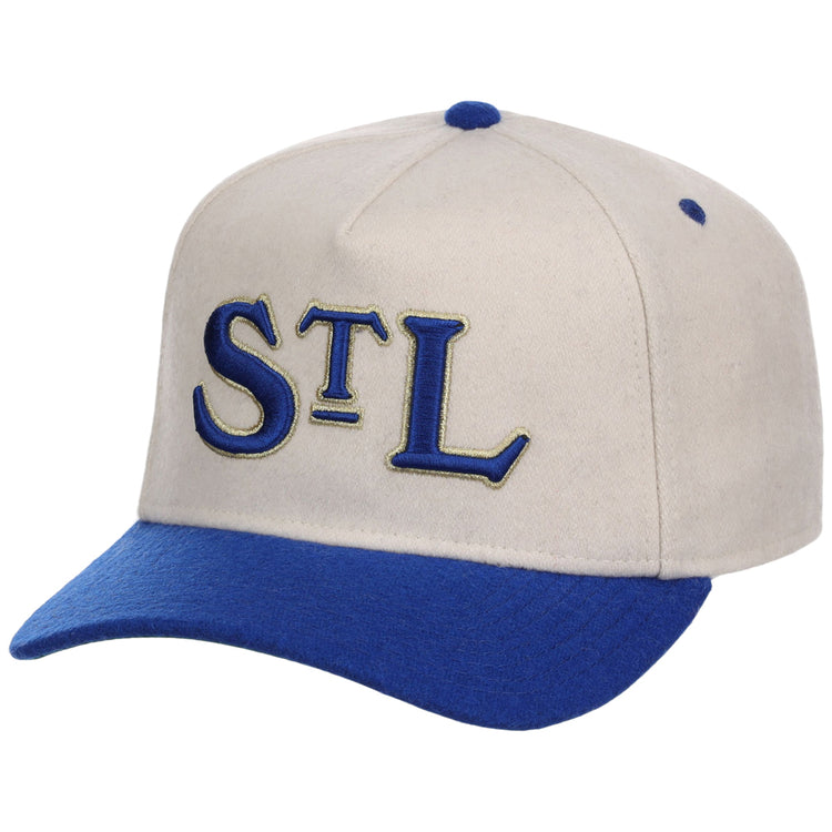 The Ebbets Field St. Louis Stars NLB Ballpark A-Frame Ballcap is beige with a royal blue brim and top button, featuring “STL” embroidered in blue and gold on the front.