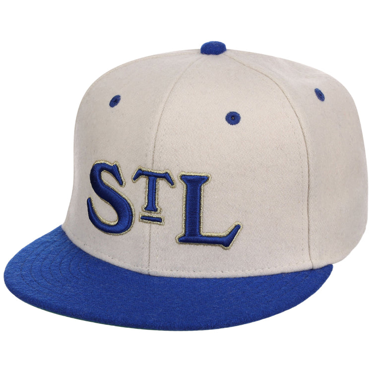 The Ebbets Field St. Louis Stars NLB Ballpark Fitted Ballcap features a beige crown, blue brim and button, and large blue “STL” letters with gold outlines embroidered on the front.