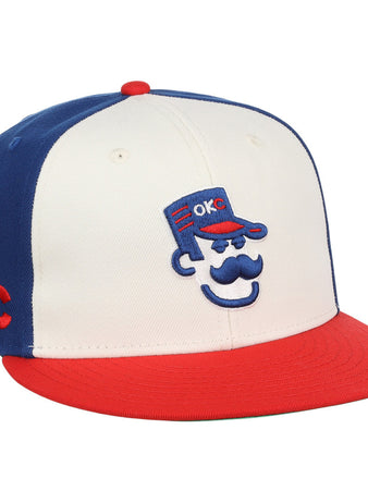 The Ebbets Field Oklahoma City 89Ers MiLB Snapback Ballcap features a white front, blue back, red brim, and a cartoon face with a blue cap embroidered with 