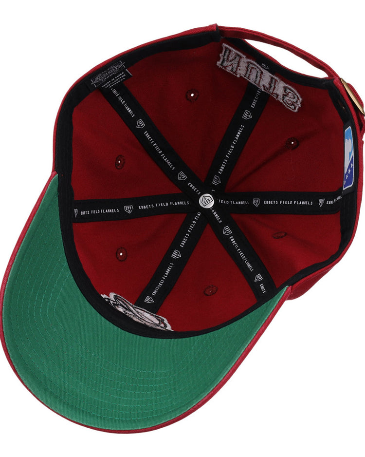 The Modesto Nuts MiLB Dad Ballcap by Ebbets Field is shown inside-out, featuring a green undervisor, black taping with white logos, a patch, and a blue and white MLB logo tag on the inner band.