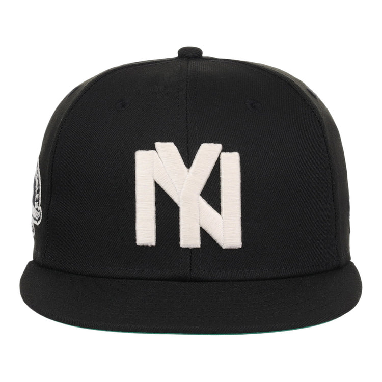 The Ebbets Field Brooklyn Eagles NLB Fitted Ballcap is a black cap with a flat brim, featuring a large white embroidered Brooklyn Eagles logo on the front.