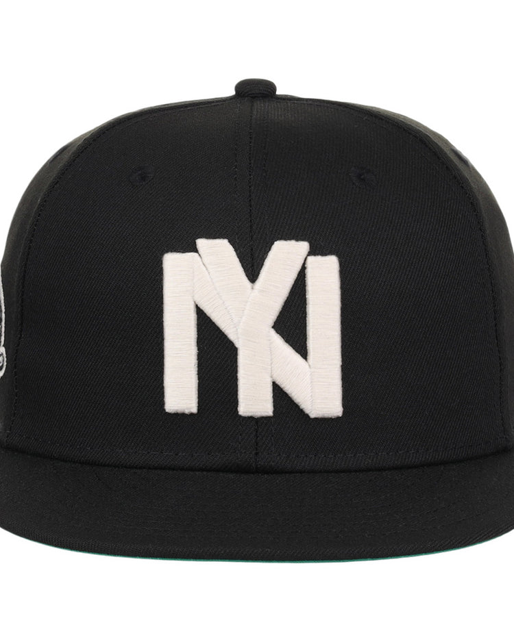 The Ebbets Field Brooklyn Eagles NLB Fitted Ballcap is a black cap with a flat brim, featuring a large white embroidered Brooklyn Eagles logo on the front.