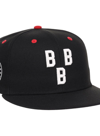 The Birmingham Black Barons NLB Varsity Fitted Ballcap by Ebbets Field is a black cap with three white embroidered Bs on the front, red accents on the top and vents, plus a circular patch with text and stars on the left side.