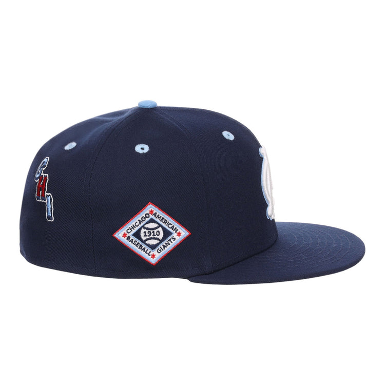 The Ebbets Field Chicago American Giants NLB Varsity Fitted Ballcap is a navy cap with a flat brim and side embroidered patches, including a diamond-shaped 1910 patch and a red, white, and blue team logo.