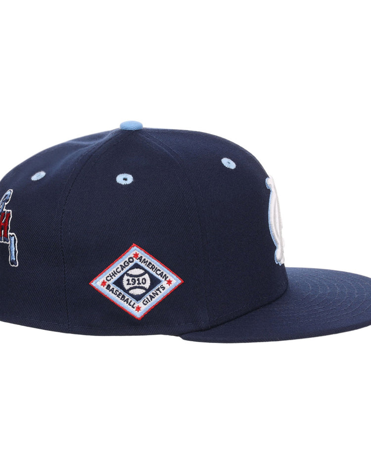 The Ebbets Field Chicago American Giants NLB Varsity Fitted Ballcap is a navy cap with a flat brim and side embroidered patches, including a diamond-shaped 1910 patch and a red, white, and blue team logo.