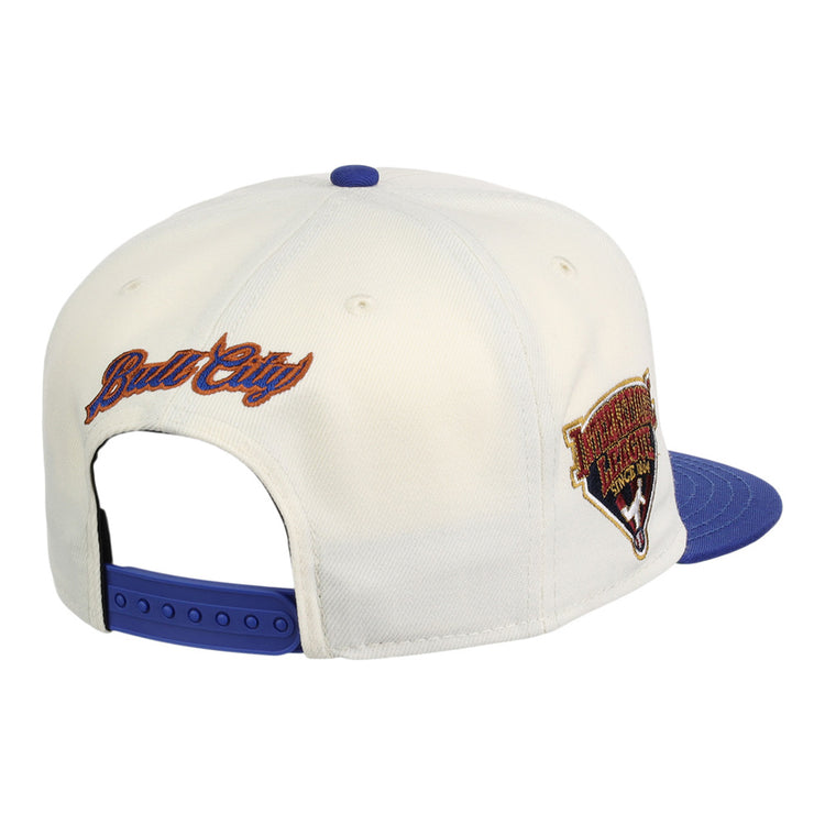 The Ebbets Field Durham Bulls MiLB Two Tone Snapback Ballcap is a white cap with a blue brim and snap closure. 