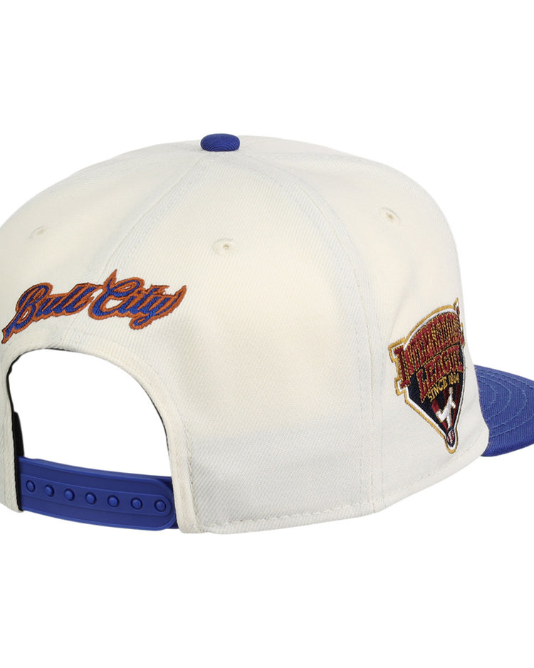 The Ebbets Field Durham Bulls MiLB Two Tone Snapback Ballcap is a white cap with a blue brim and snap closure. 