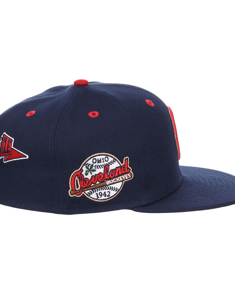 The Ebbets Field Cleveland Buckeyes NLB Varsity Fitted Ballcap is a navy blue cap with red and white patches, including a triangular pennant and round 