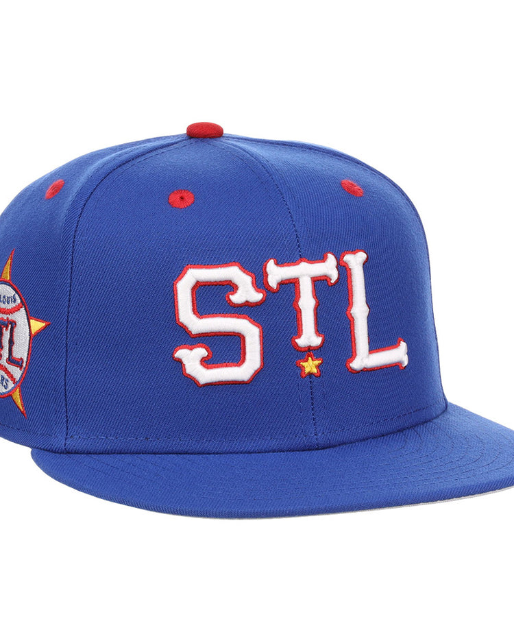 The Ebbets Field St. Louis Stars NLB Varsity Fitted Ballcap features a royal blue design, “STL” in bold white and red on the front, a side “St. Louis” patch, red accents, and a flat brim.