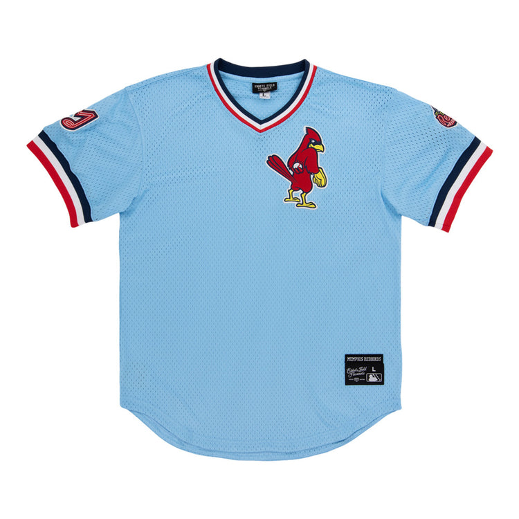A light blue Ebbets Field Memphis Redbirds MiLB V-Neck Jersey with red, white, and navy trim, a cardinal logo on the chest, and patches on both sleeves.