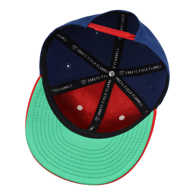 The Oklahoma City 89Ers MiLB Snapback Ballcap by Ebbets Field features a green underbrim, red brim edge, blue and red crown, and black interior bands labeled Ebbets Field.