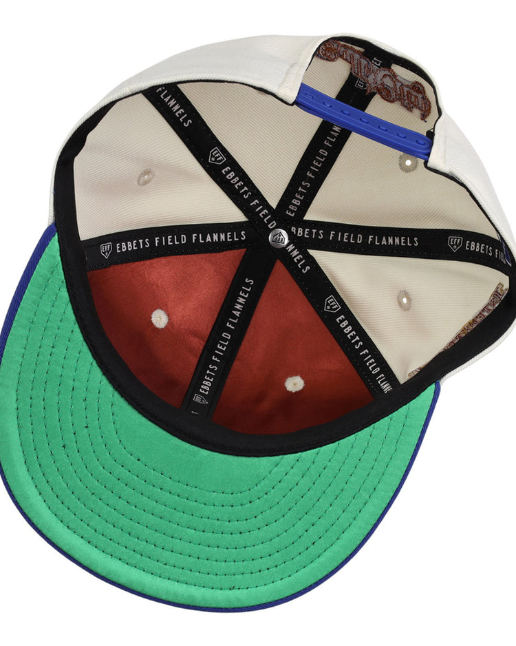 The underside of the Ebbets Field Durham Bulls MiLB Two Tone Snapback Ballcap features a green brim, brown crown panels, black EBBETS FIELD FLANNELS taped seams, and a blue adjustable strap at the back.
