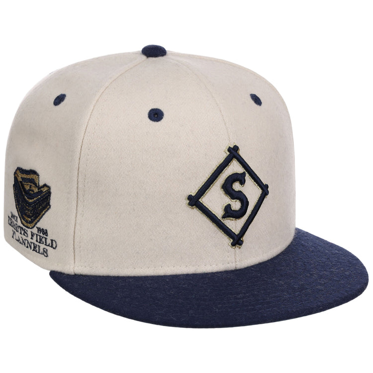 The Ebbets Field Seattle Steelheads NLB Ballpark Fitted Ballcap features a beige crown, navy brim, button, and eyelets. A navy diamond 
