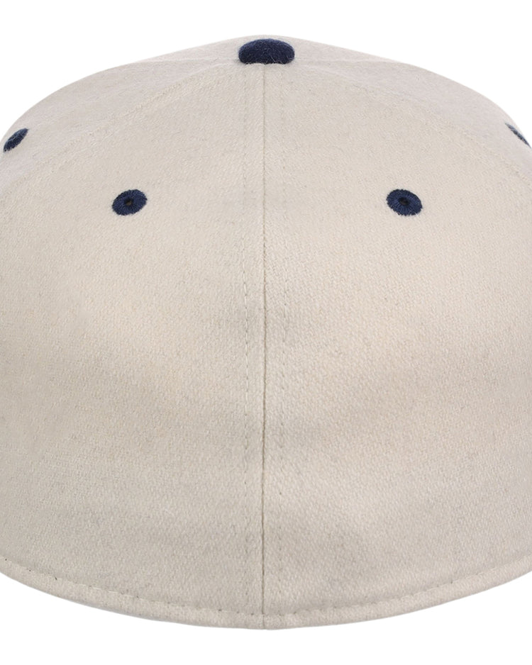 The Ebbets Field Chicago American Giants NLB Ballpark Fitted Ballcap is beige, shown from the back with dark blue ventilation eyelets, a navy top button, and visible stitching that divides the cap into panels.