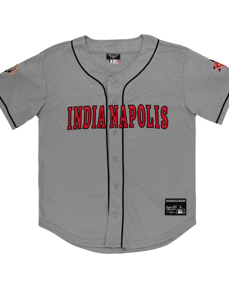 The Ebbets Field Indianapolis Indians MiLB Button Down Jersey is gray with black trim, bold red INDIANAPOLIS lettering on the chest, sleeve patches, and visible tags by the collar and bottom hem.