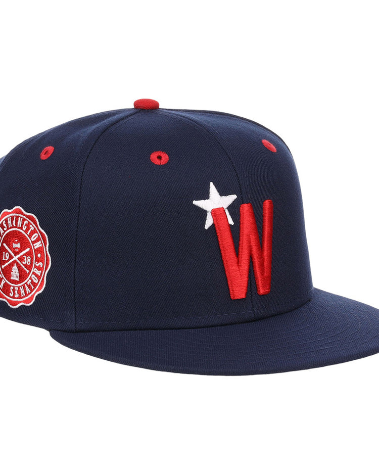 The Ebbets Field Washington Black Senators NLB Varsity Fitted Ballcap features a navy design, red and white W logo with star on the front, a side Nationals patch, flat brim, and red eyelets.