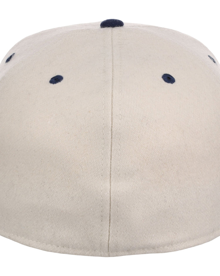 The Ebbets Field Atlanta Black Crackers NLB Ballpark Fitted Ballcap is beige, shown from the back with a central seam and four navy blue ventilation holes near the top.